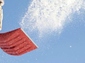 qtq80-D2IBVt Shoveling snow with a red snow shovel in winter snowstorm.
